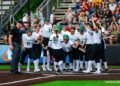 team meets at home plate after a home run.