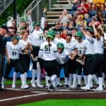 team meets at home plate after a home run.