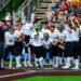 team meets at home plate after a home run.