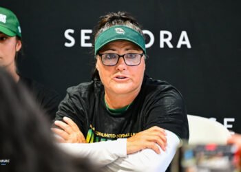 Talons Lisa Fernandez in black shirt and green visor.